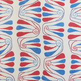 Detail of fabric in an abstract floral stripe in red and blue on a cream field.