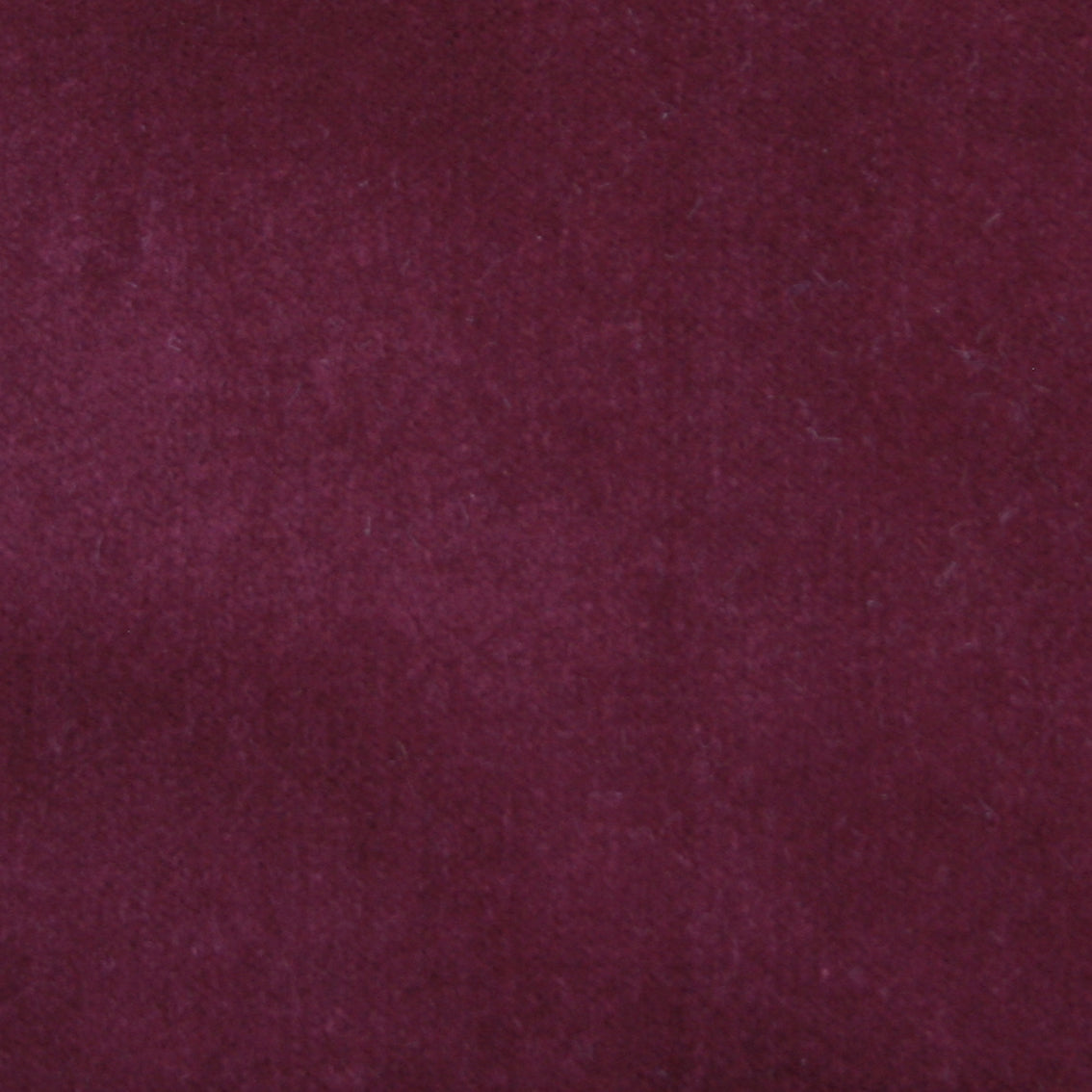 Detail of velvet fabric yardage in maroon.