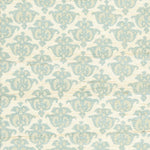 Detail of fabric in a repeating damask print in blue and tan on a cream field.