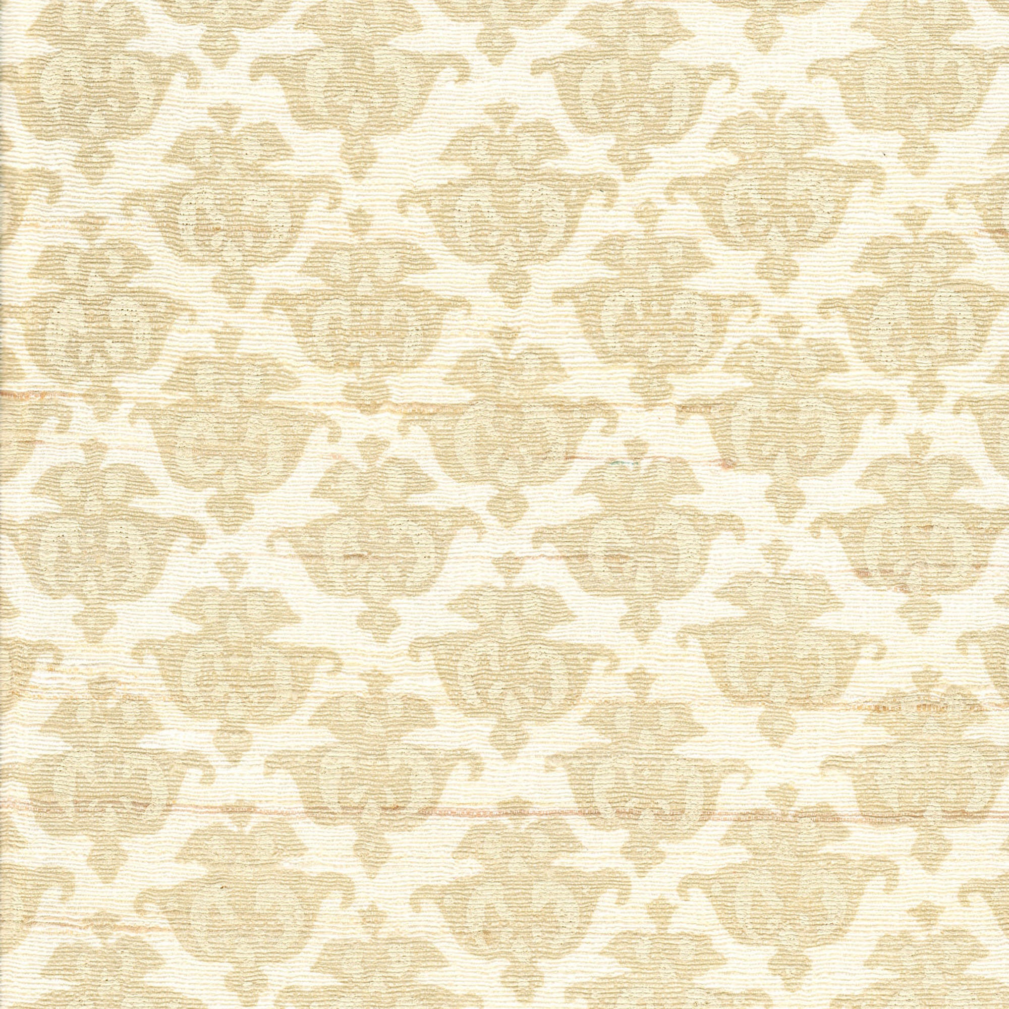 Detail of fabric in a repeating damask print in tan and cream on a white field.