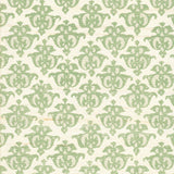 Detail of fabric in a repeating damask print in green and tan on a cream field.