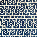 Detail of wallpaper in a repeating "X" print in indigo on a cream field.