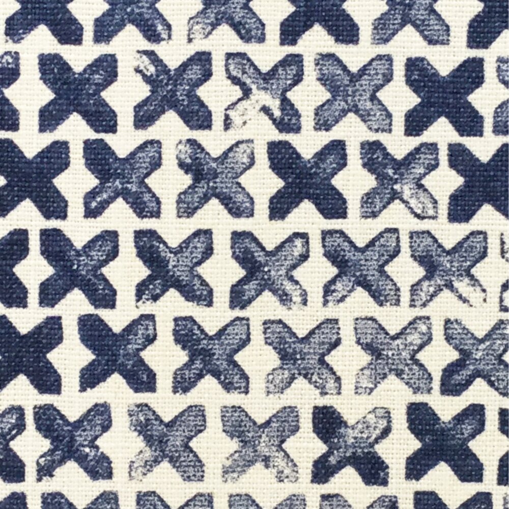 Close-up of fabric in a repeating "X" print in indigo on a cream field.