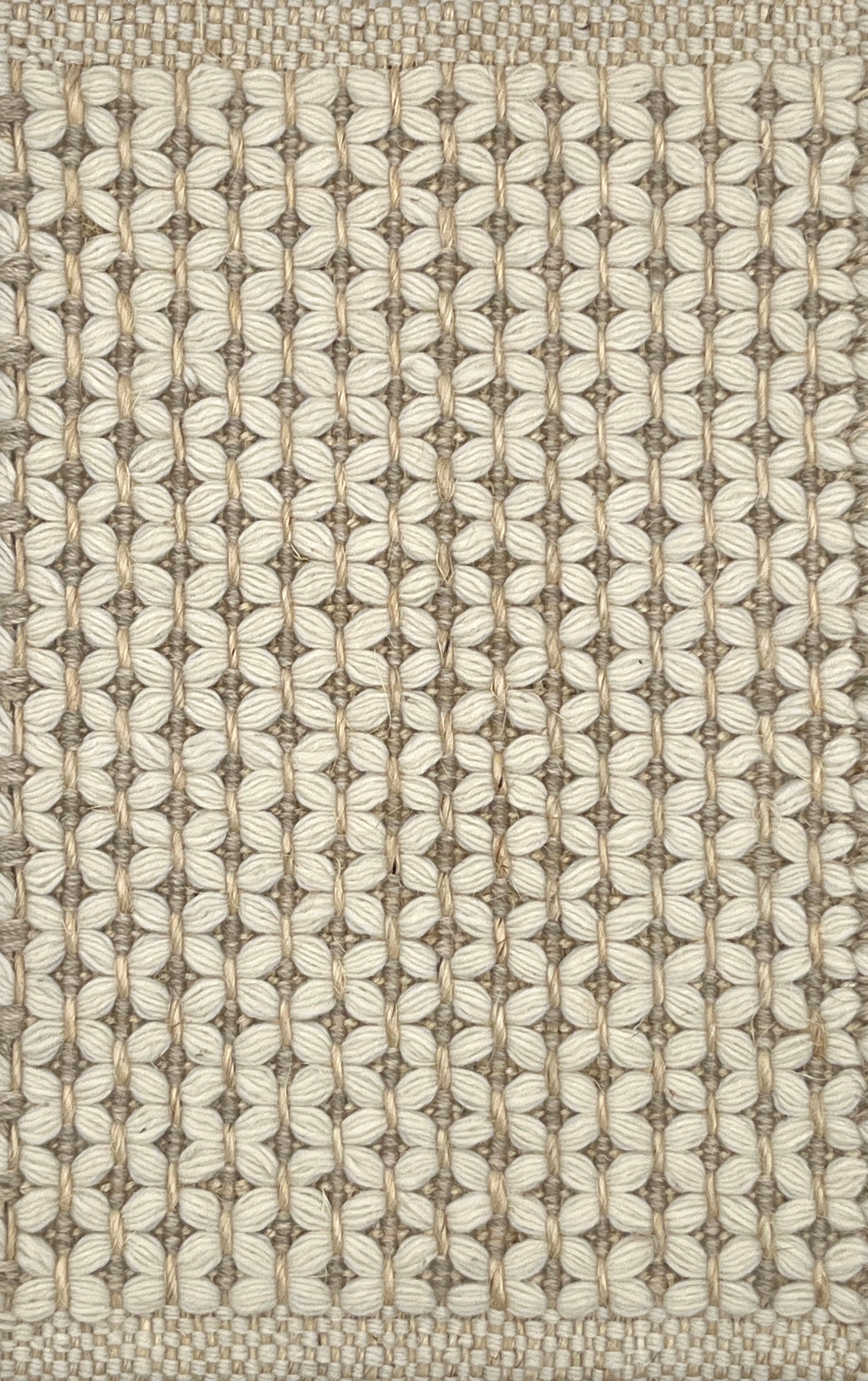 Textured flatweave carpet with a grid-like design in neutral colors.