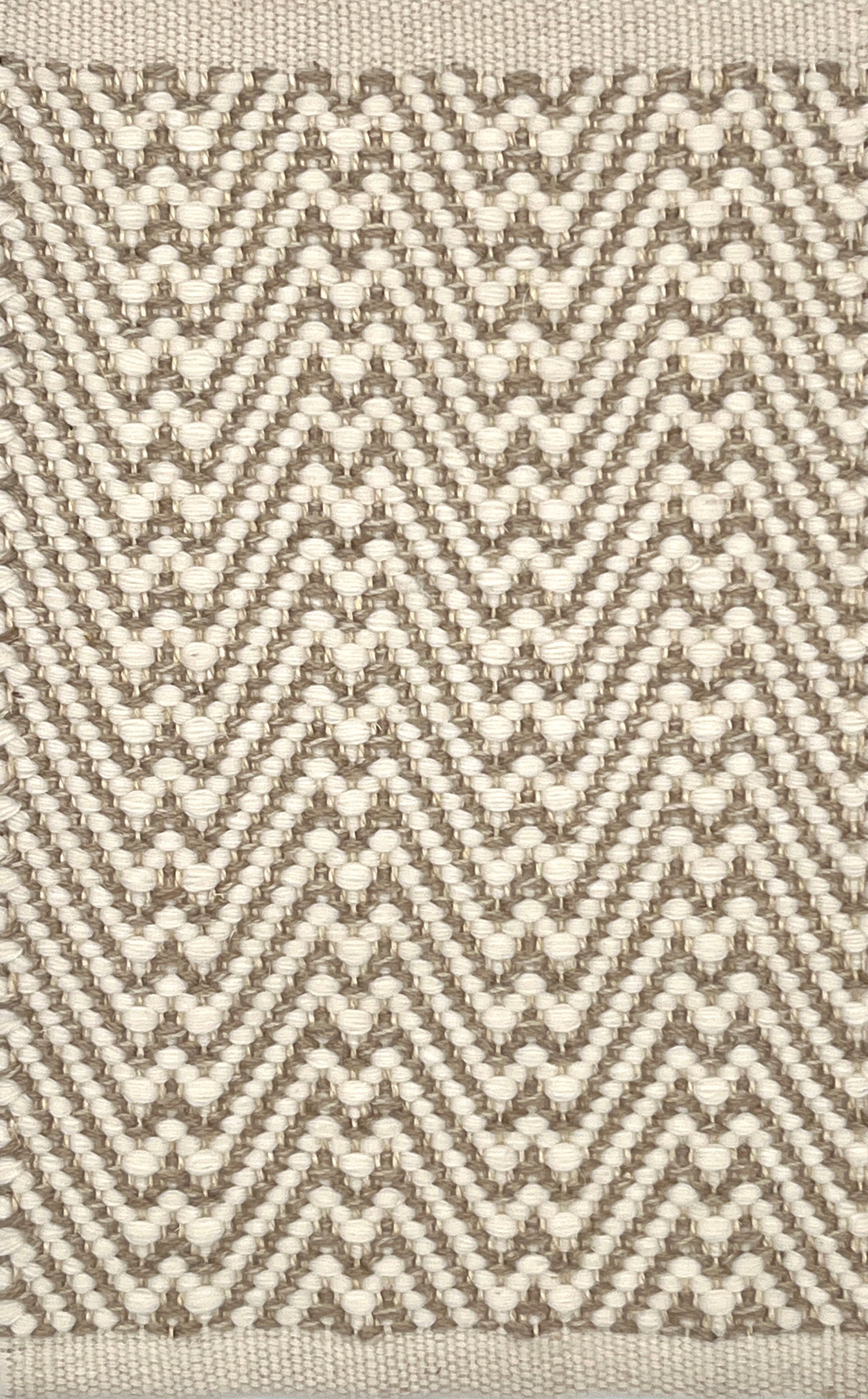 Flatweave rug with a zigzag pattern in beige and brown on a neutral background