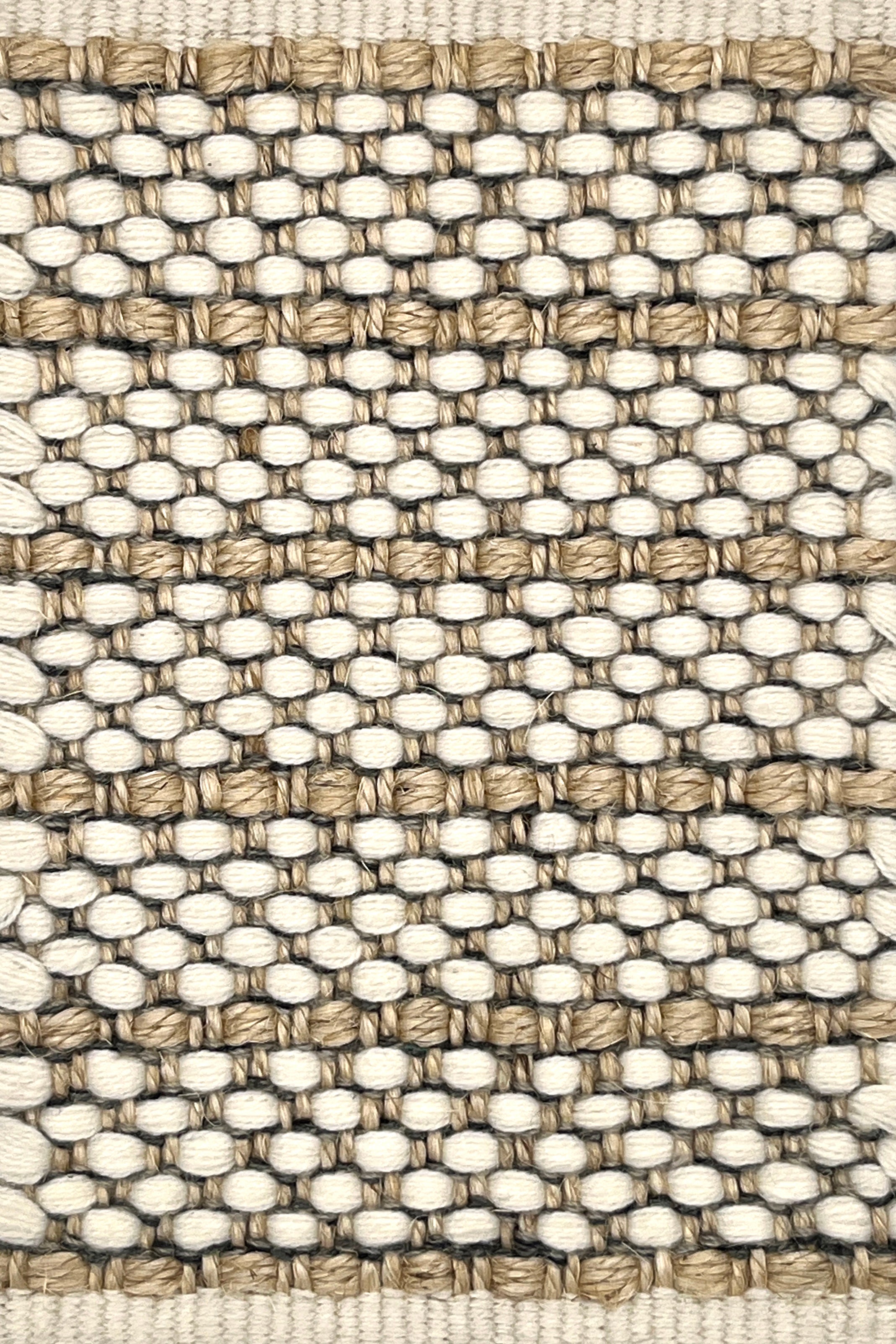 Close-up of a woven striped rug with beige and white colors.