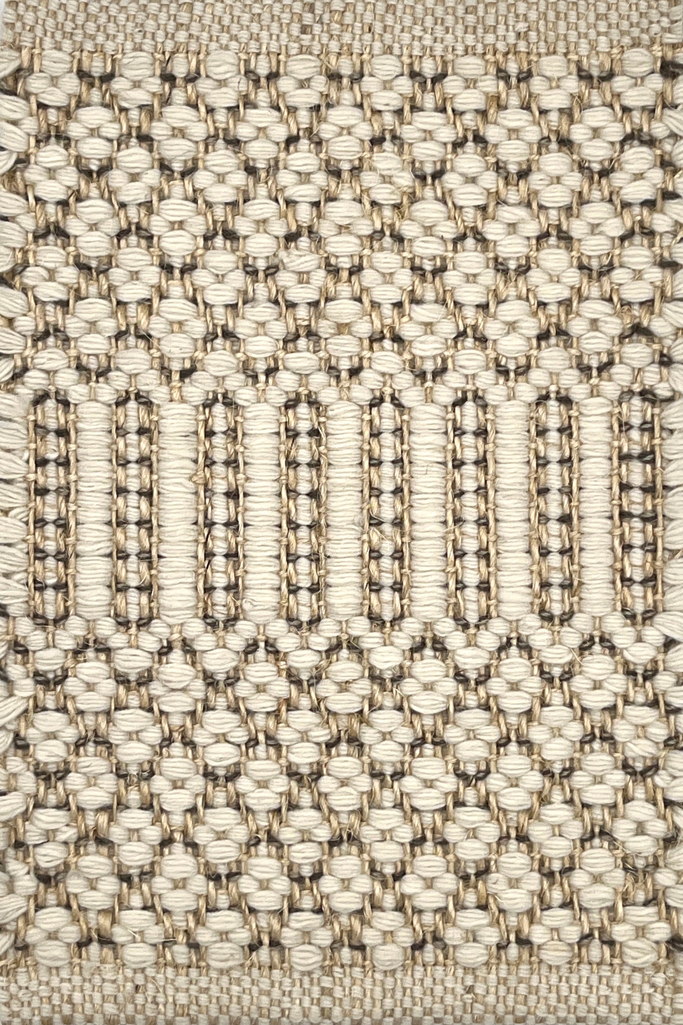 Close-up of a textured flatweave rug with a geometric pattern