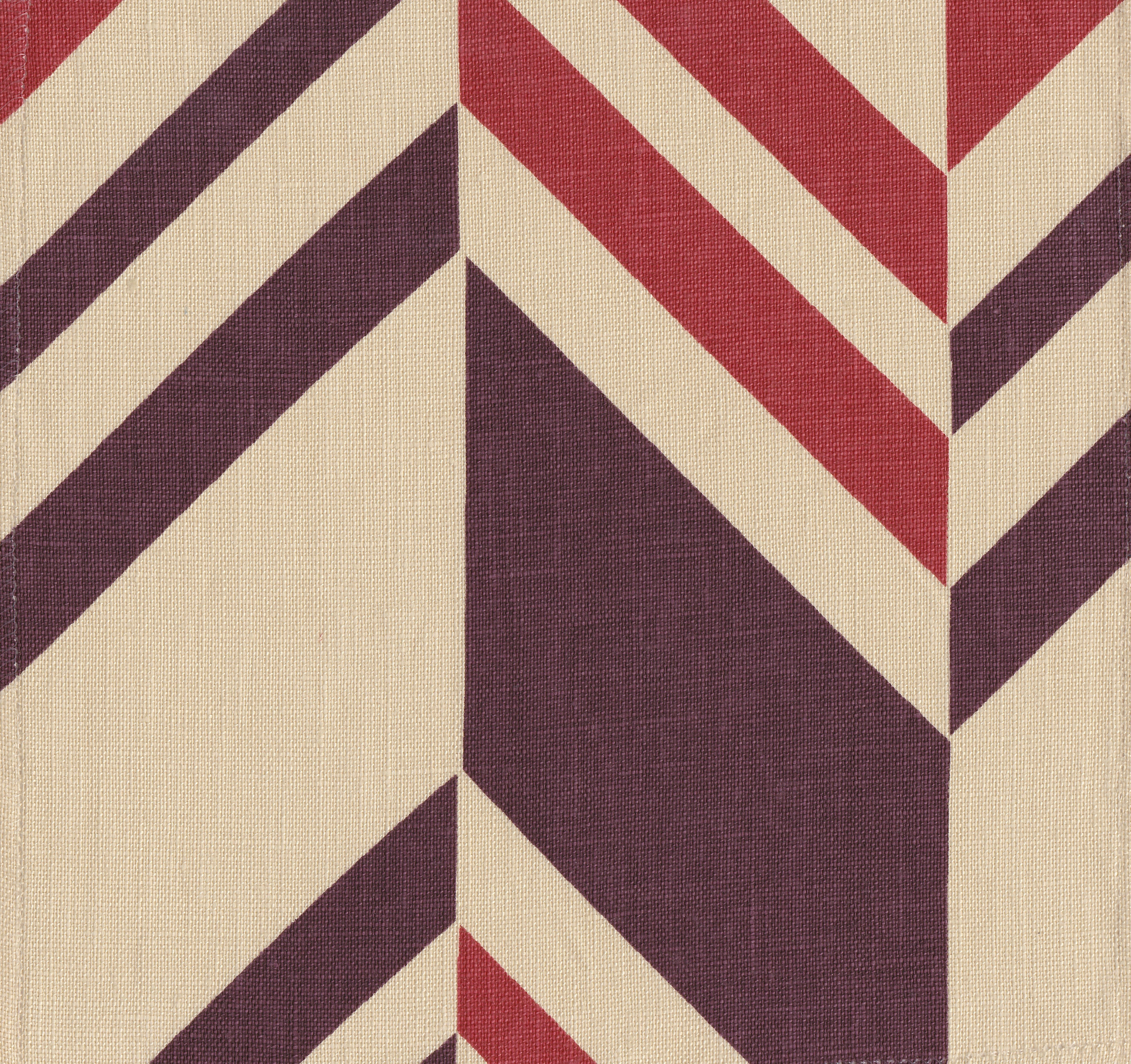 Detail of fabric in an irregular chevron stripe in red and purple on a cream field.