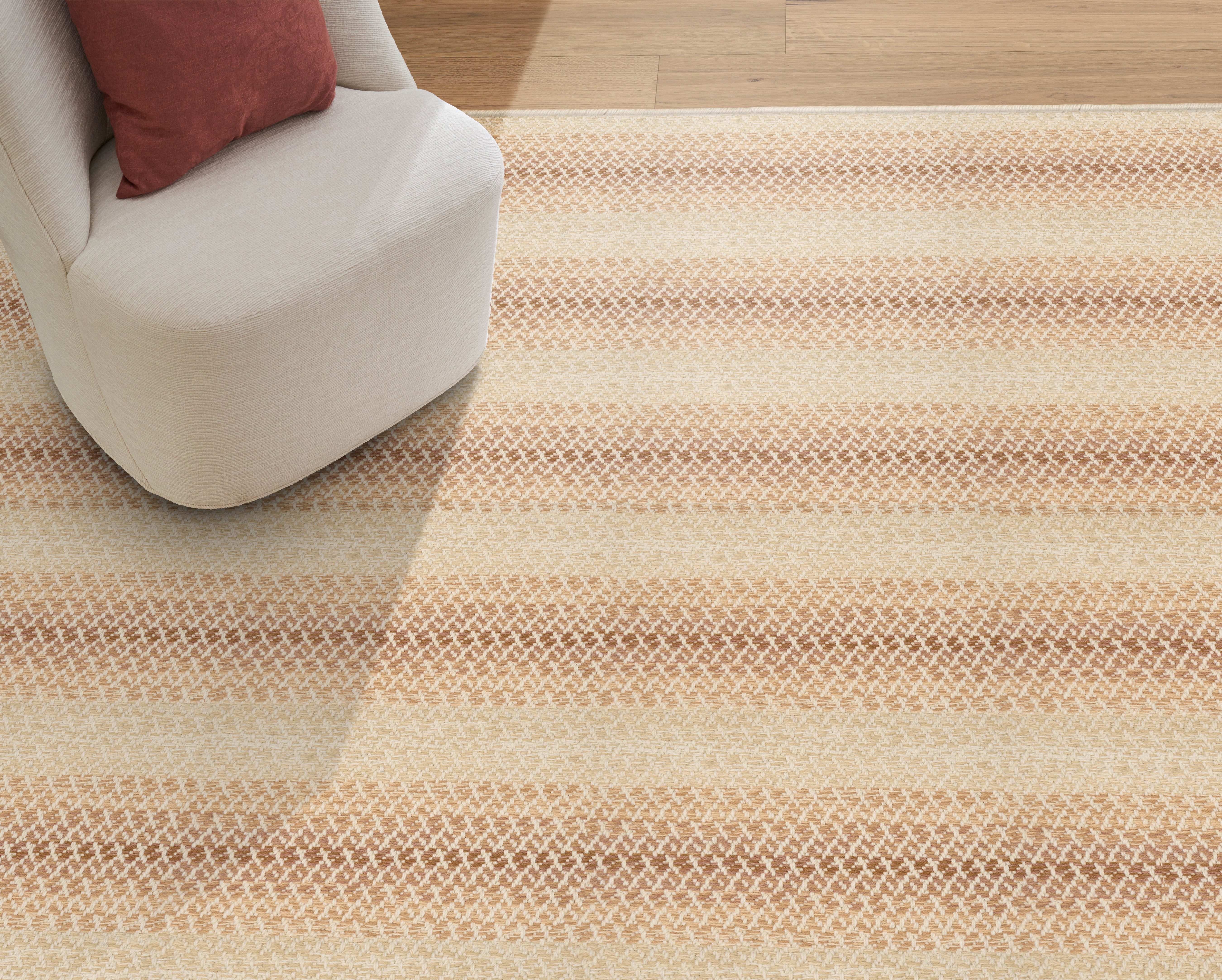 Beige striped rug on a wooden floor with a white chair and red cushion.