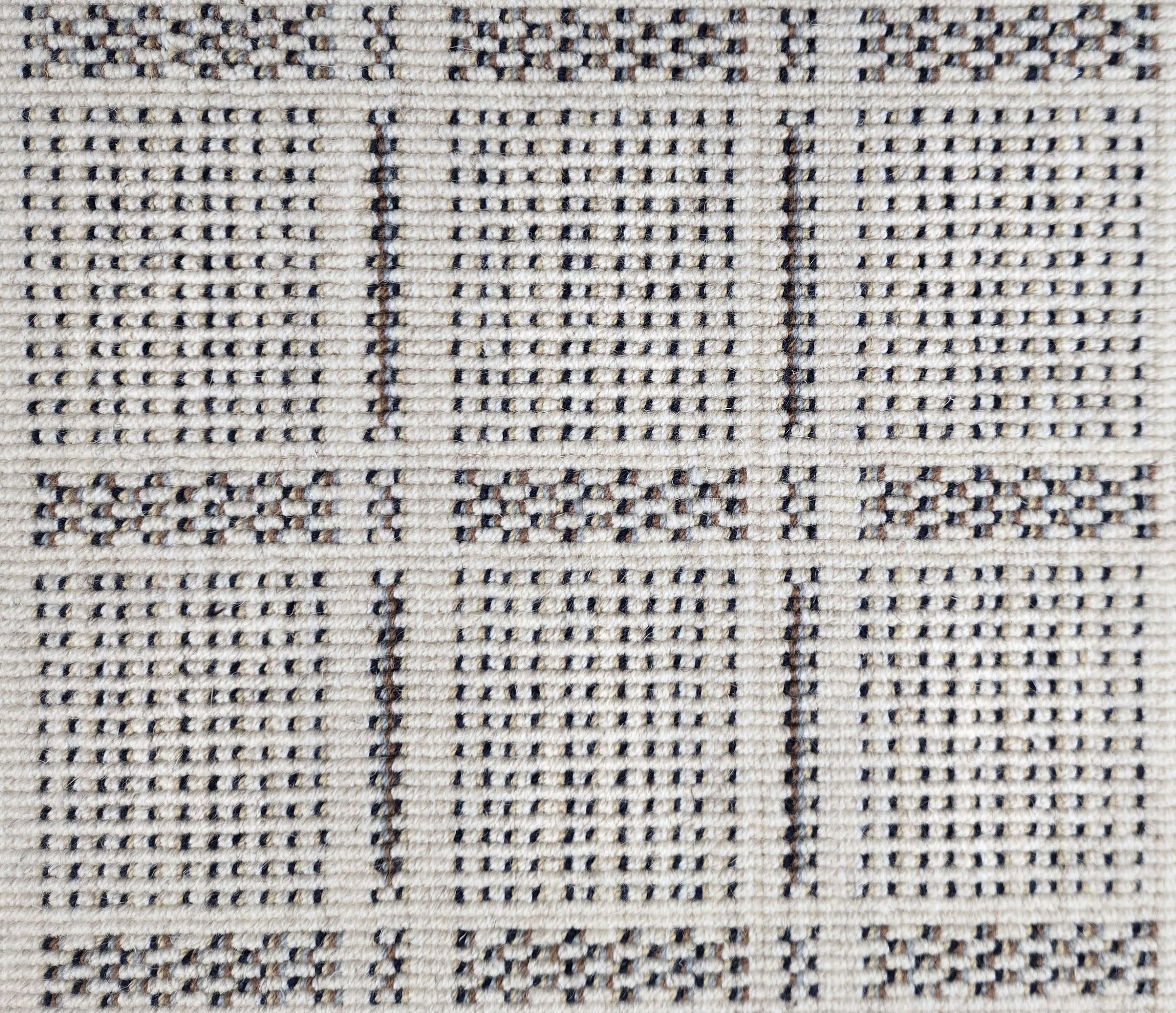 Broadloom carpet in check pattern in shades of brown and blue with cream. 