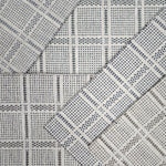 Broadloom carpet samples in a plaid pattern in a range of neutral colors. 