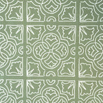 Detail of fabric in a damask lattice print in white on a sage field.