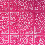 Detail of fabric in a damask lattice print in white on a fuchsia field.