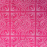 Detail of fabric in a damask lattice print in white on a fuchsia field.