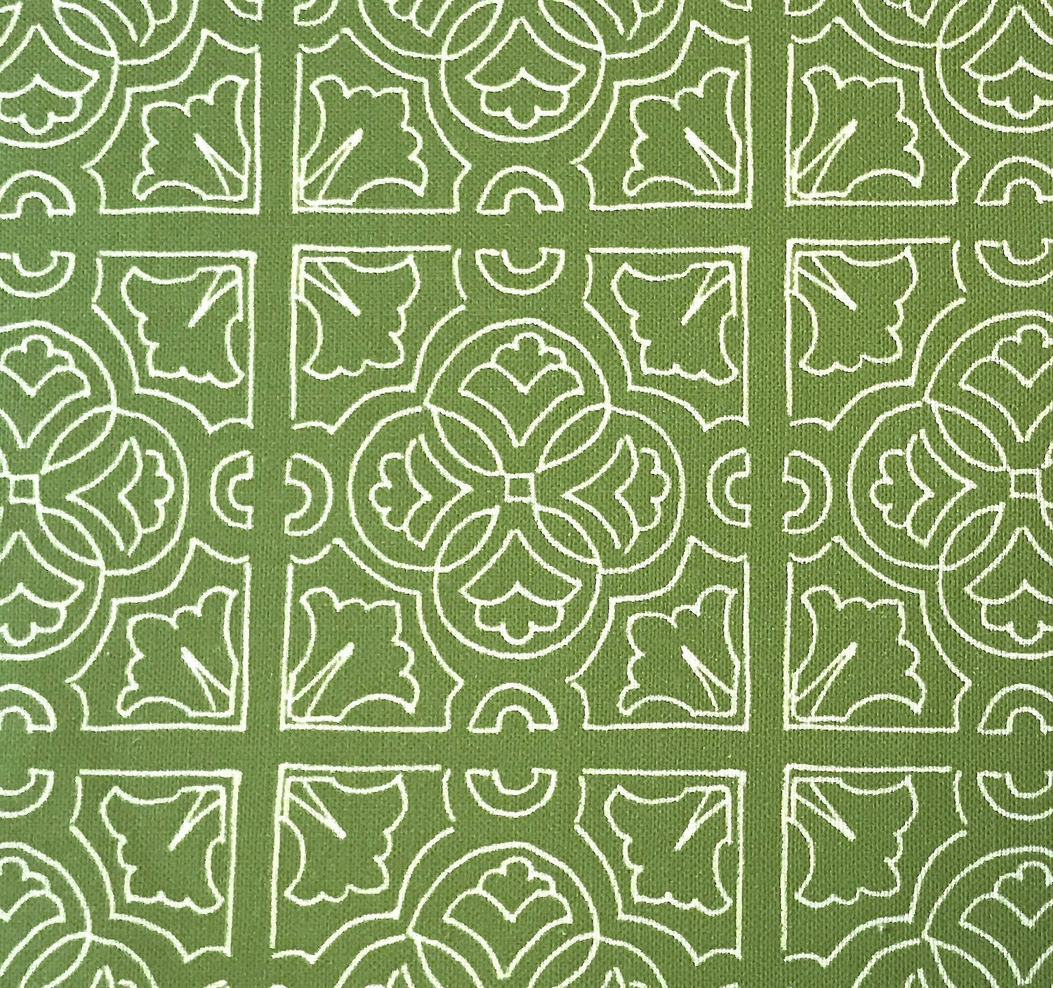 Detail of fabric in a damask lattice print in white on a green field.