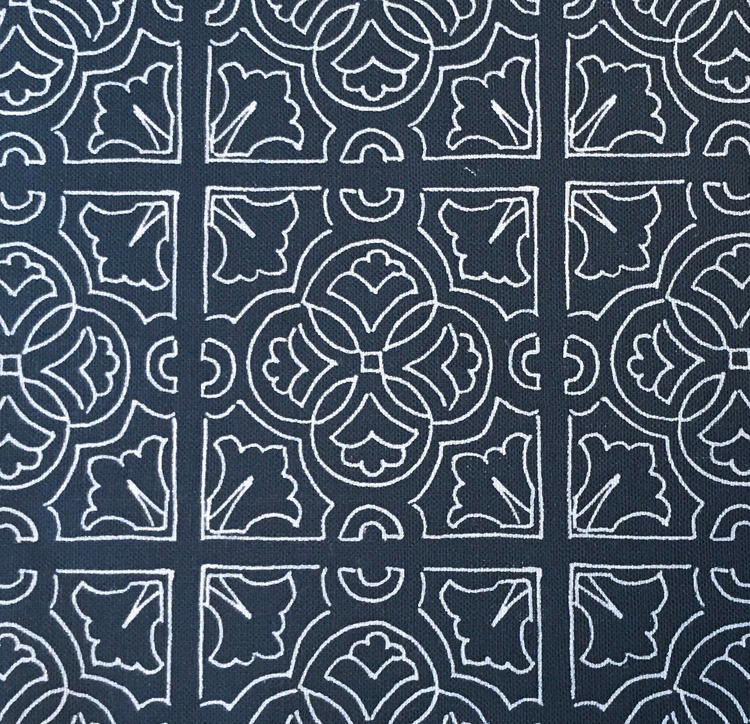 Detail of fabric in a damask lattice print in white on a navy field.