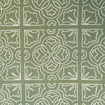 Detail of fabric in a damask lattice print in white on a sage field.