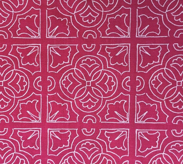 Detail of fabric in a damask lattice print in pink on a fuchsia field.