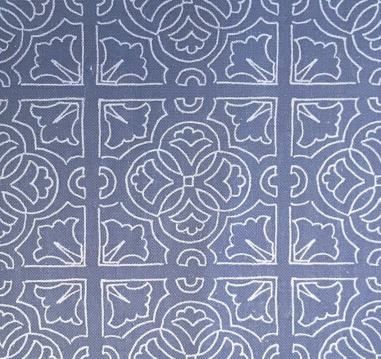 Detail of fabric in a damask lattice print in white on a blue field.