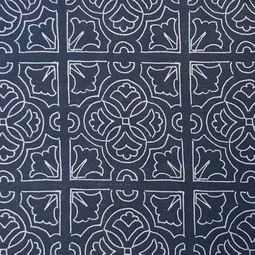 Detail of fabric in a damask lattice print in white on a navy field.