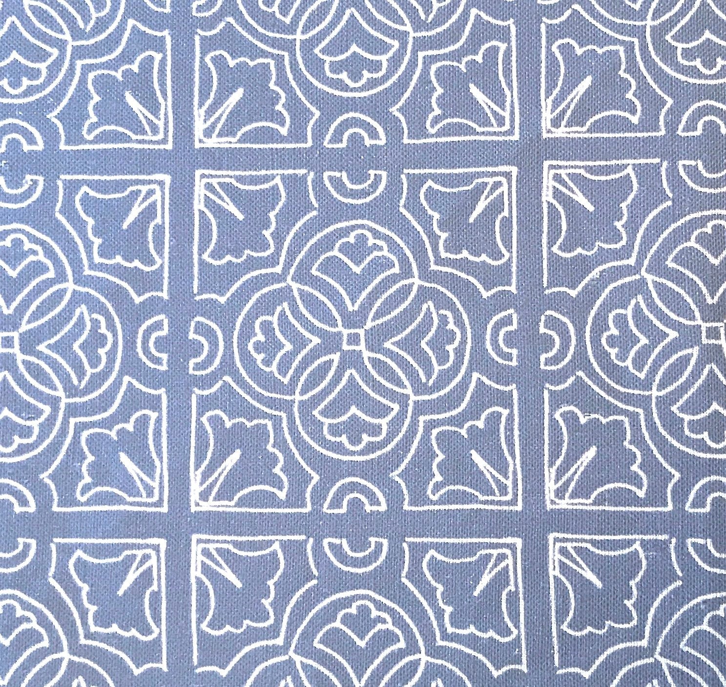 Detail of fabric in a damask lattice print in white on a blue field.