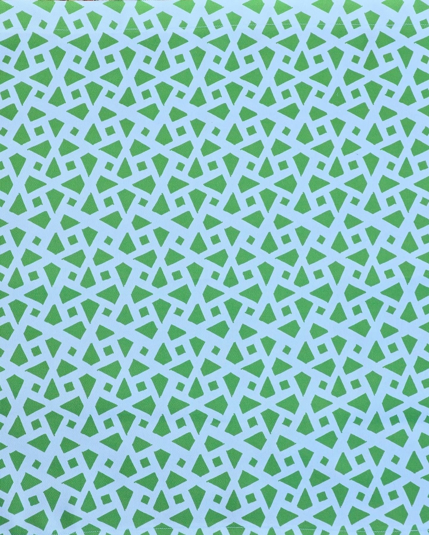 Detail of fabric in a geometric lattice print in green on a light blue field.