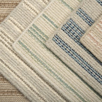 Stack of striped broadloom carpet samples in an array of colors. 