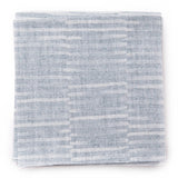 A stack of fabric swatches in a small-scale checked pattern in shades of light blue.