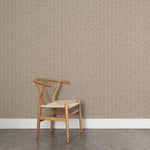 A wooden chair stands in front of a wall papered in a small-scale checked pattern in shades of dusty brown.