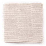 A stack of fabric swatches in a small-scale checked pattern in shades of cream.