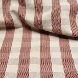 Detail of a draped hand-woven cotton fabric in soft cream in a plaid windowpane patter in cream, maroon, tan and orange.