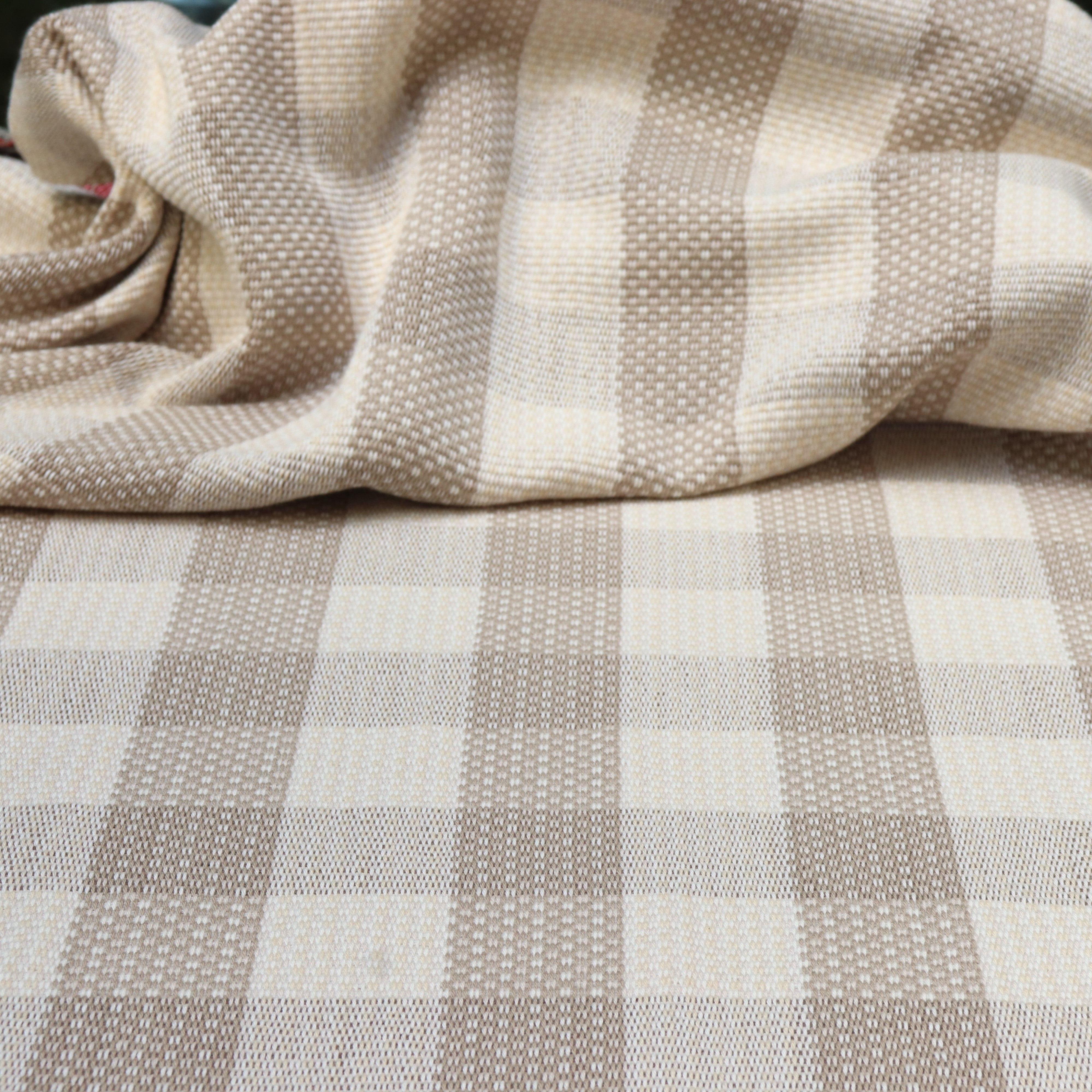 Draped handwoven fabric in a window pane check in cream and taupe.