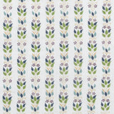 Detail of fabric in a striped botanical print in shades of blue, purple and green on a white field.