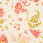 Detail of fabric in a bird and botanical print in shades of red and yellow on a cream field.