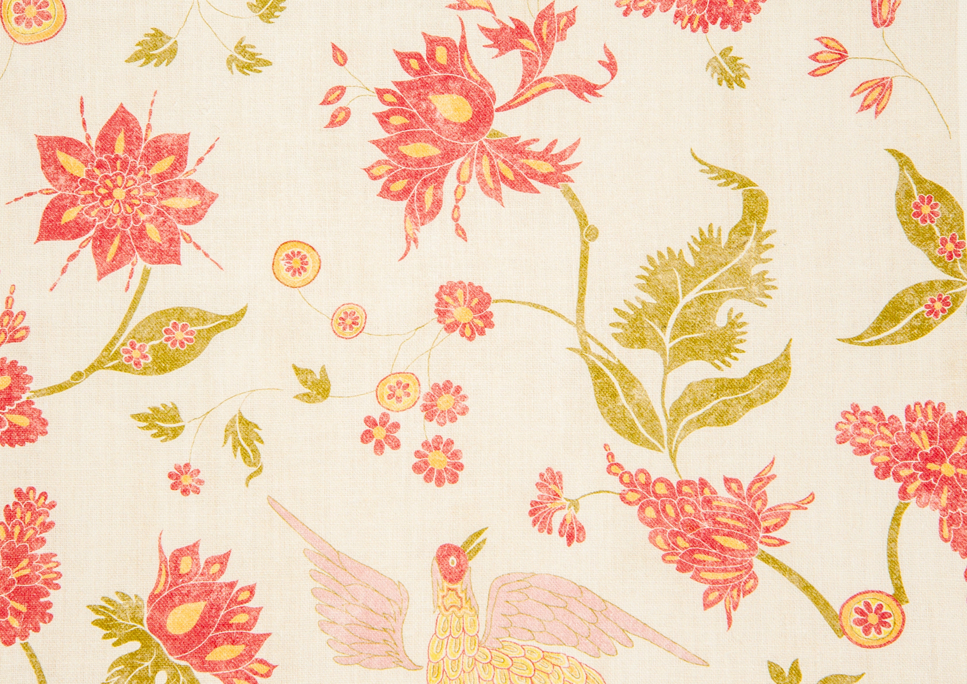 Detail of fabric in a bird and botanical print in shades of red and yellow on a cream field.