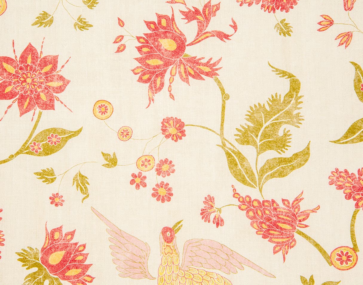 Detail of wallpaper in a bird and botanical print in shades of red and yellow on a cream field.