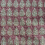 Detail of fabric woven in a repeating leaf print in shades of purple and turquoise.