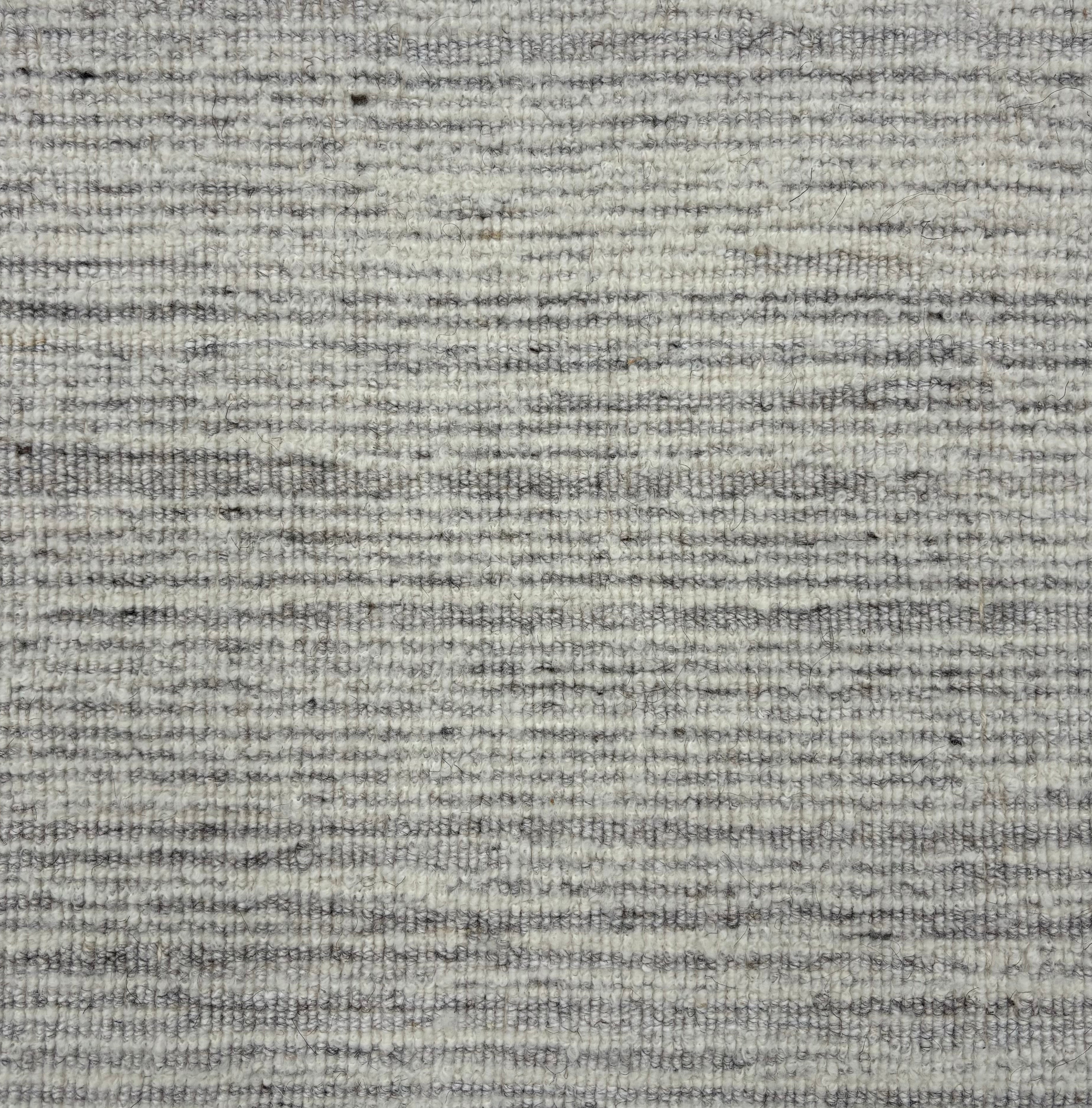 Handknotted rug sample in a textural blend of soft heathered grey and white. 