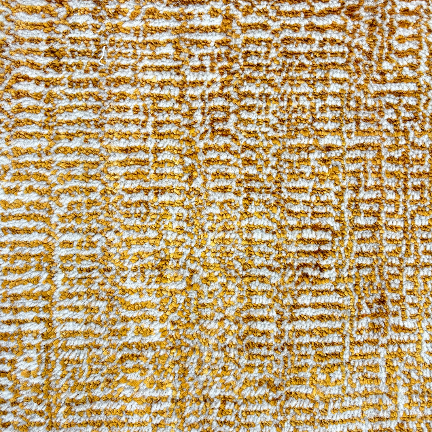 Handknotted rug sample in a textural blend of amber and ivory. 