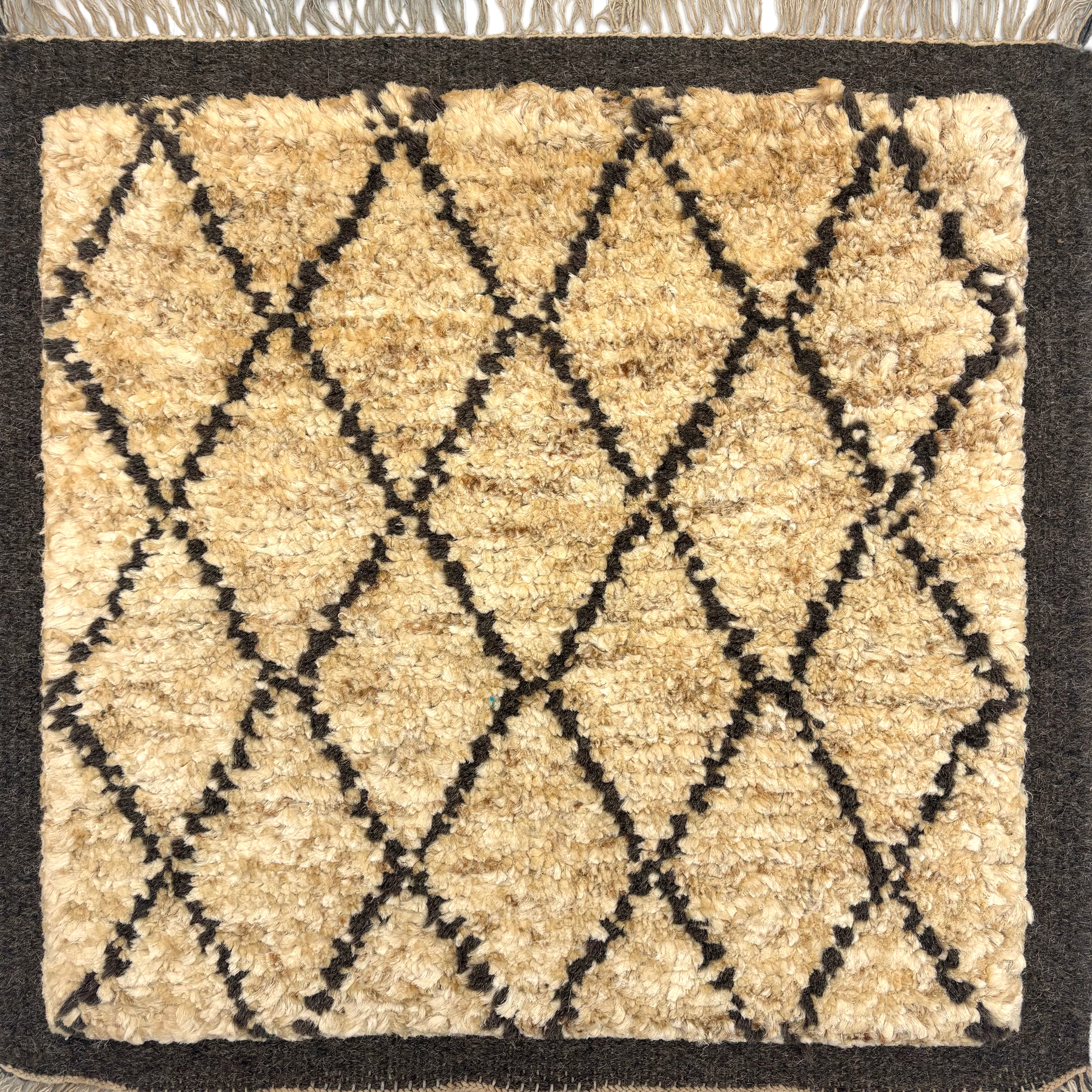 Handknotted Rug in the Moroccan style in a charcoal grey lattice motif and border against a tan wool field. 