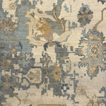 Handknotted carpet in an old word damask floral in shades of muted blue, cream and tan. 