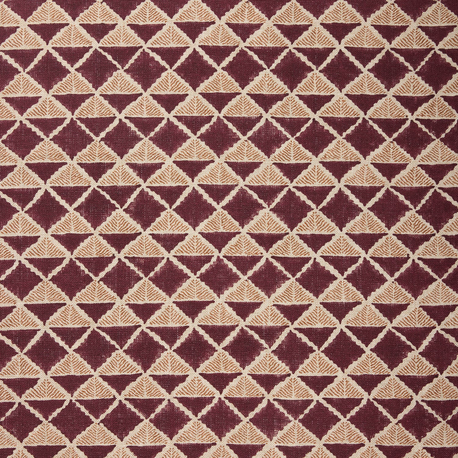 Fabric with a geometric pattern of triangles in wine purple and brown.