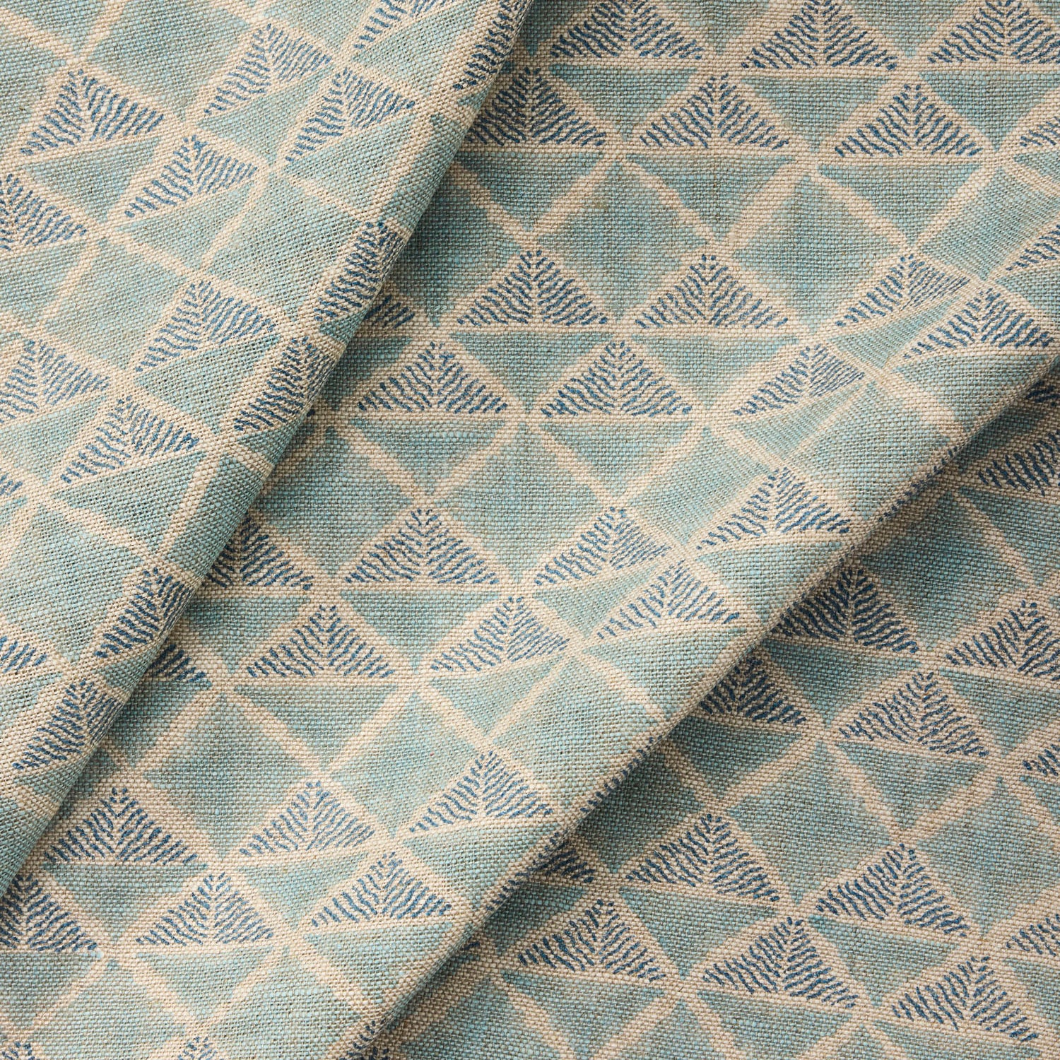 Textile with a geometric pattern of triangles in shades of blue.
