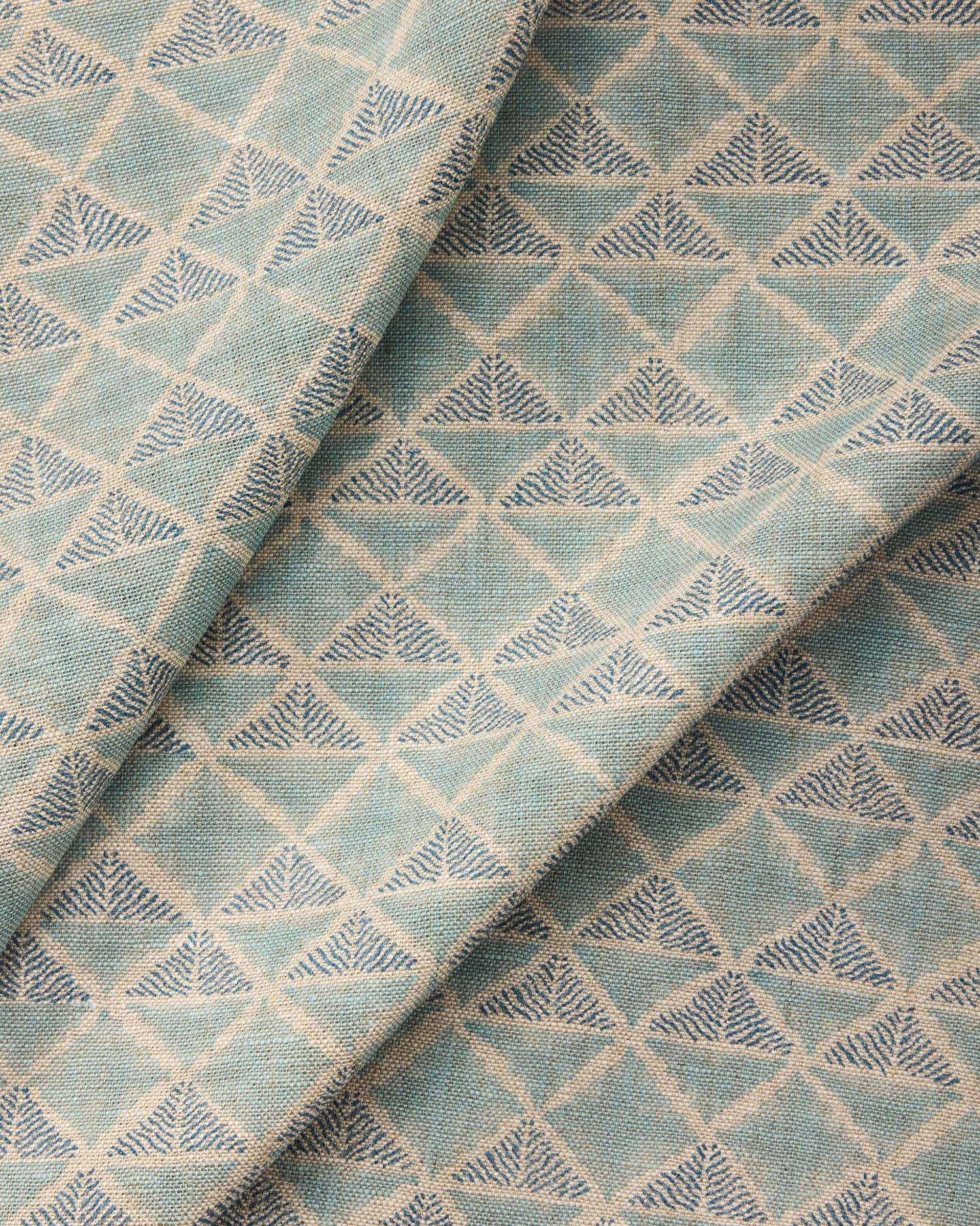 Textile with a geometric pattern of triangles in shades of blue.