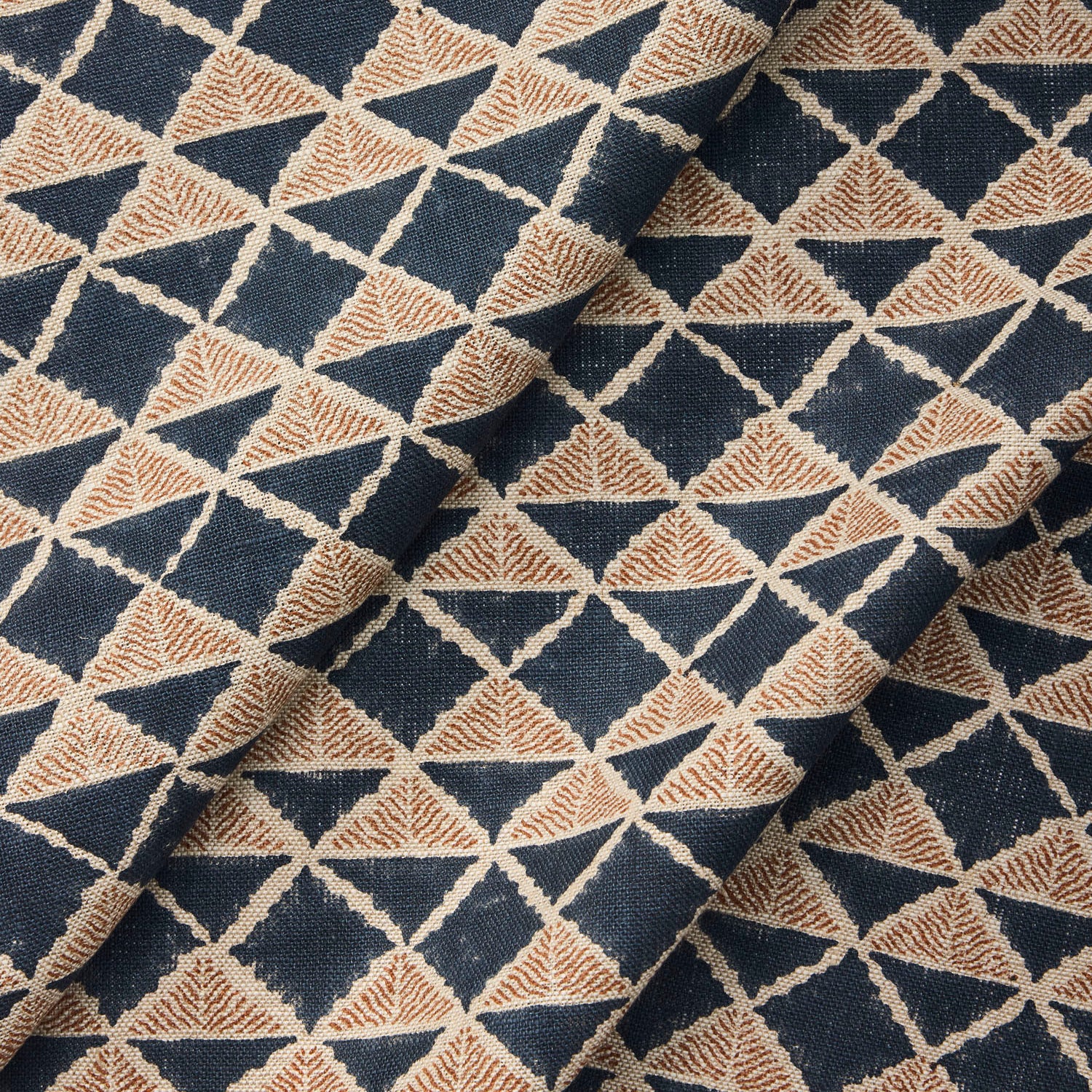 Draped fabric with a geometric pattern of triangles in navy blue and brown.