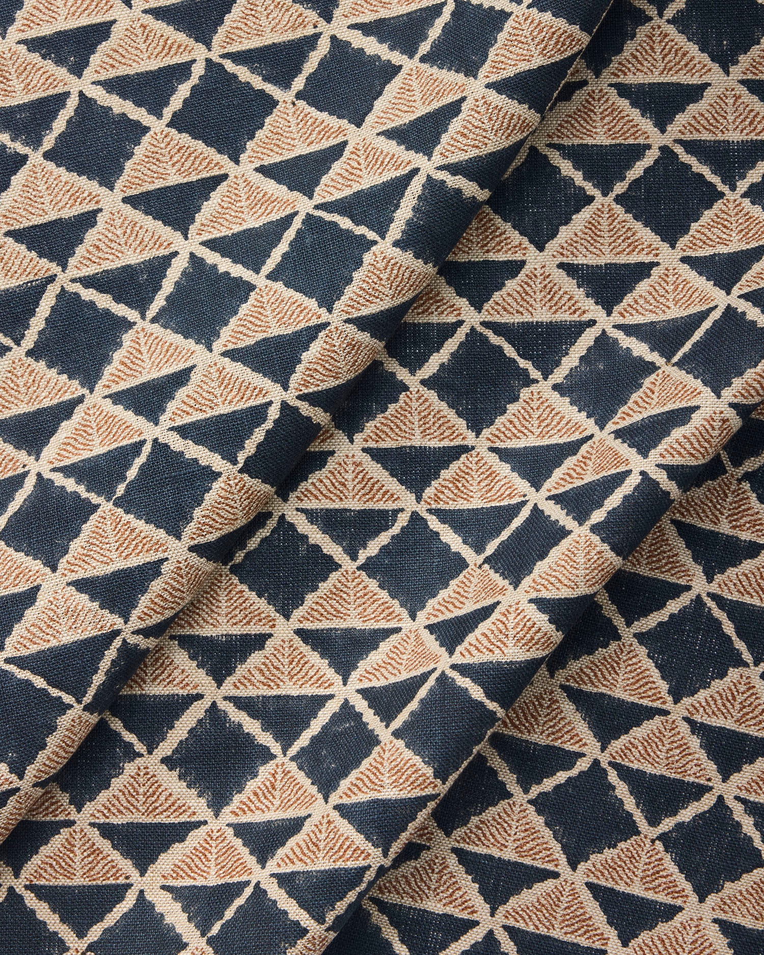 Draped fabric with a geometric pattern of triangles in navy blue and brown.