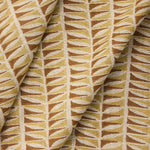 Draped close-up of fabric with a geometric leaf pattern in brown and beige.