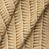 Draped close-up of fabric with a geometric leaf pattern in brown and beige.
