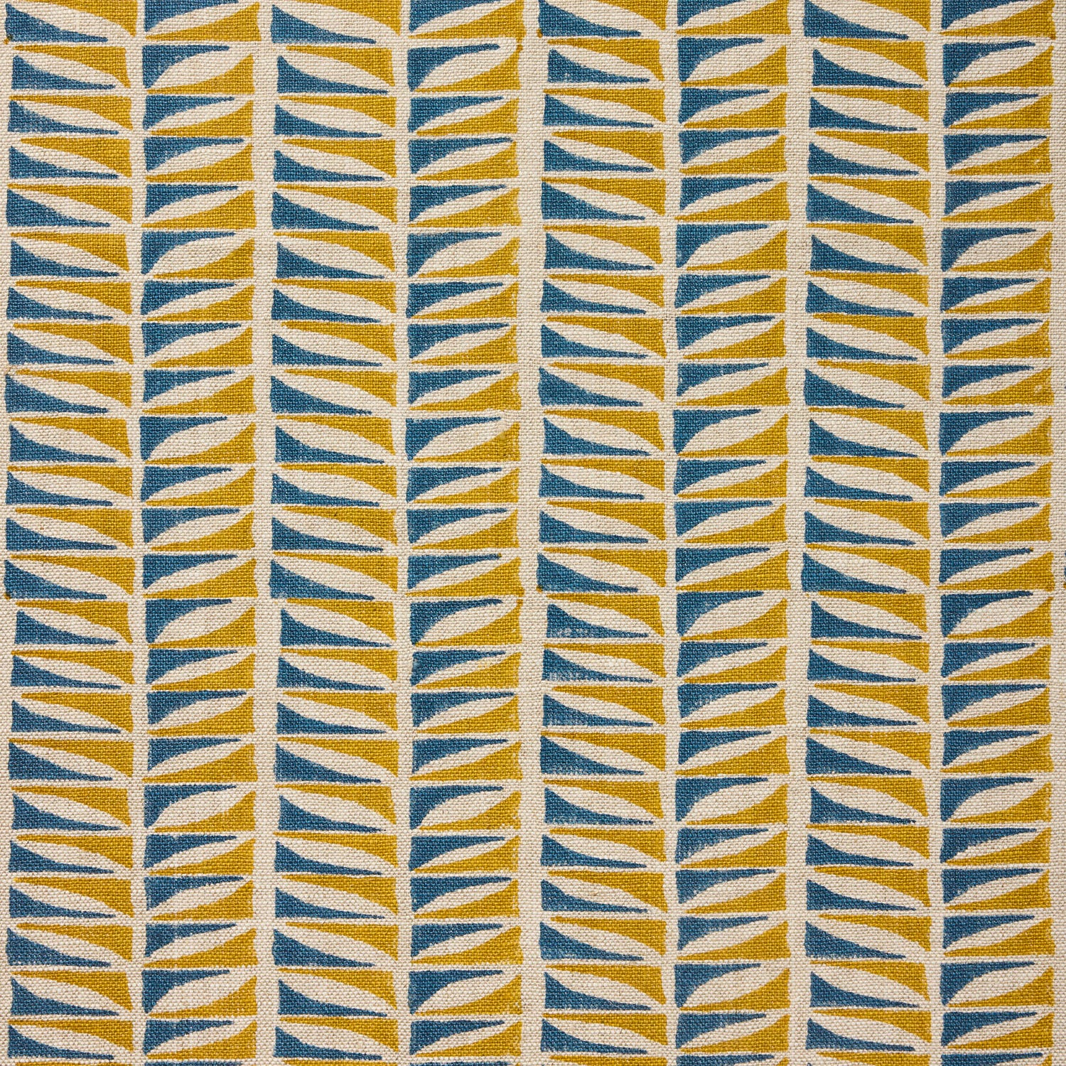 Close-up of fabric with a geometric leaf pattern in blue and ochre.