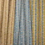 Three fabric swatches with geometric leaf pattern in blue, beige, and multicolor.